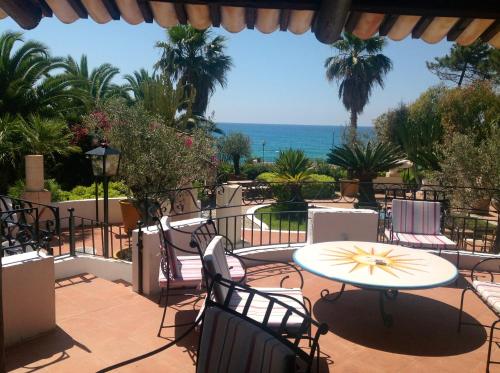 a patio with a table and chairs and the ocean at Residenza Villa Spagnola in Parghelia