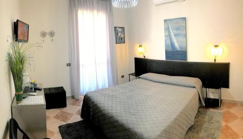 1 dormitorio con 1 cama grande y 2 lámparas en Magralù 2 B&B, en Alghero