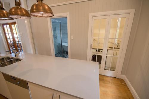 a kitchen with a white counter top in a room at Beautiful Queenslander in Townsville