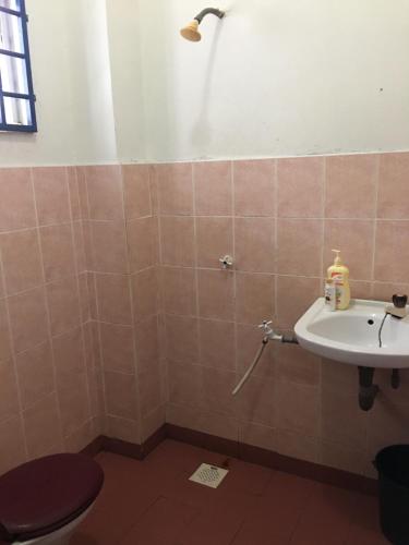 La salle de bains est pourvue de toilettes et d'un lavabo. dans l'établissement Homestay Pagar Buruk Ipoh, à Ipoh