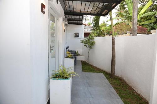 a hallway of a white house with potted plants at The Classic-hostel-apt-deluxe in Weligama