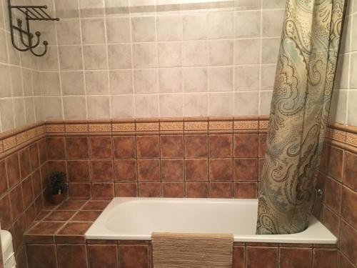 a bath tub with a shower curtain in a bathroom at Casa Rural Valle del Palancia in Castellnovo