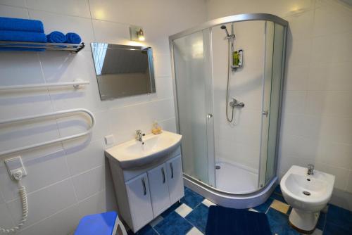 uma casa de banho com um chuveiro, um lavatório e um WC. em Apartment 5A em Kaunas
