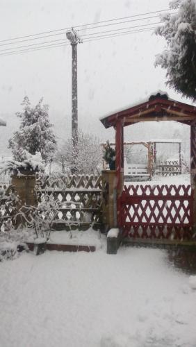a snow covered yard with a fence and a gazebo at U Tří Koček in Jablonné v Podještědí