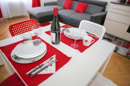 a white table with a bottle of wine and glasses at Stylish apartment a few steps from metro in Prague