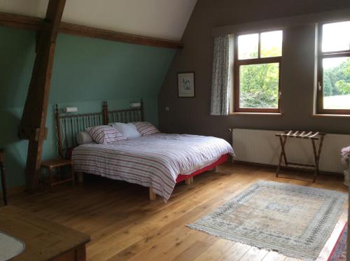 a bedroom with a bed and a window and a rug at Haras de Baudemont in Ittre