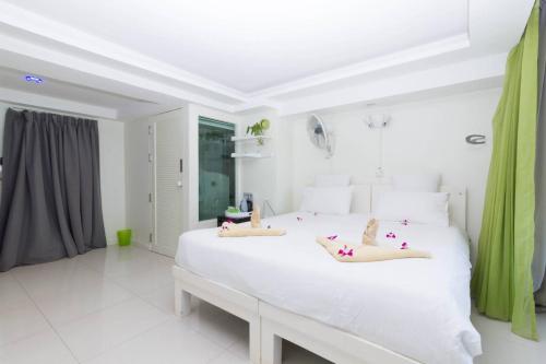 a white bedroom with a large white bed with pillows at Mama Beach Residence - Adults Only in Phi Phi Don