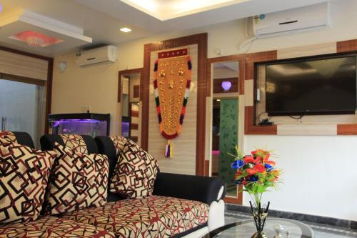 a living room with a couch and a tv at Sri Sarvesha Residency Temple view in Tiruvannāmalai
