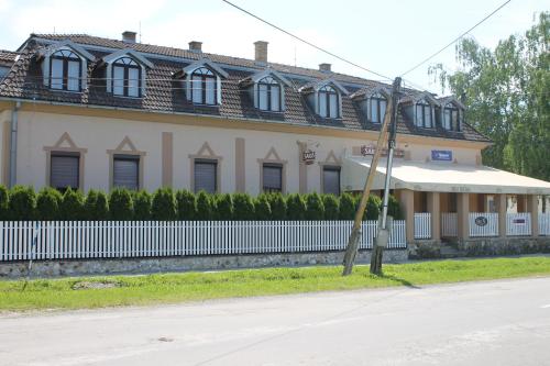 a large house with a white fence in front of it at Ubytovanie Toscana in Vyšné Revištia