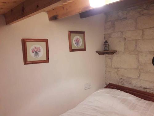 a bedroom with two pictures on the wall and a bed at John' s House in Omodos in Limassol