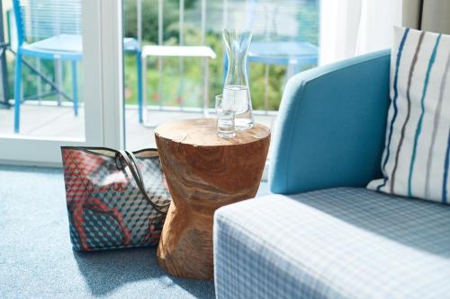 a glass vase on a wooden stump next to a chair at Seehotel Kressbronn in Kressbronn am Bodensee