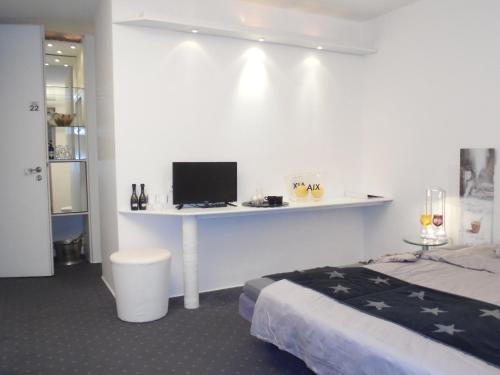 a bedroom with a bed and a desk with a computer at Pallazzo Alfonso in Aachen