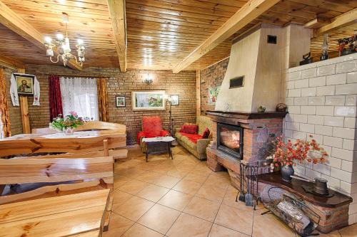 a large living room with a fireplace in a house at Aleksandrówka - Domek Aleksander in Trześcianka