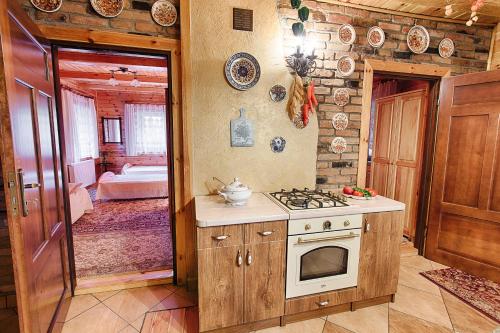 eine Küche mit einem Herd und ein Zimmer mit einem Schlafzimmer in der Unterkunft Aleksandrówka - Domek Aleksander in Trześcianka