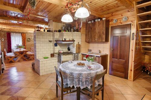 a kitchen with a table and chairs in a room at Aleksandrówka - Domek Aleksander in Trześcianka
