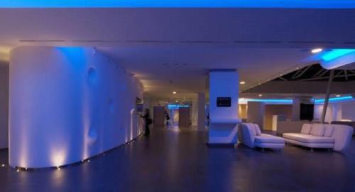 a lobby with white chairs and a person in a building at A Point Arezzo Park Hotel in Arezzo