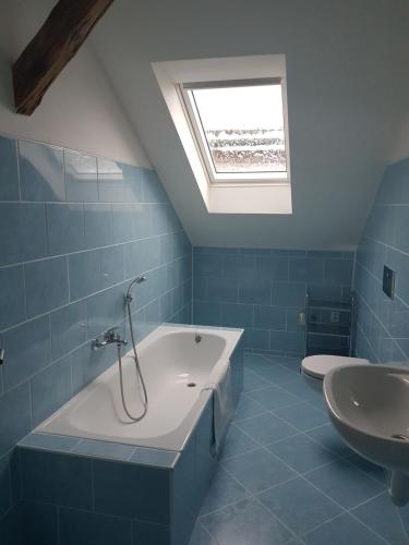 een blauwe badkamer met een bad en een wastafel bij Městský Hotel Dorinka in Hostinné