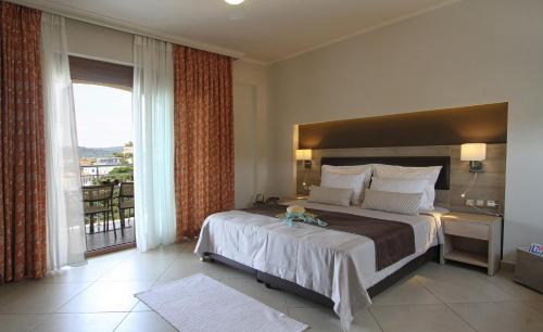 sypialnia z dużym łóżkiem i dużym oknem w obiekcie Skinari Apartments w mieście Monolia