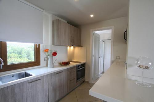 a kitchen with a white counter top and a window at Skinari Apartments in Monolia