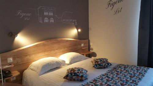 a bedroom with a bed with two pillows on it at Best Western Le Pont d'Or in Figeac