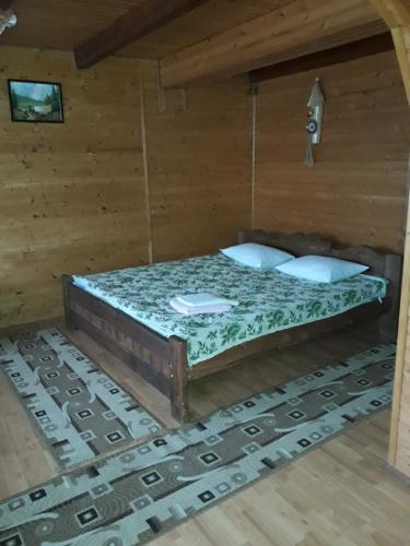 a bedroom with a bed in a wooden room at Sadyba Ellada in Yaremche