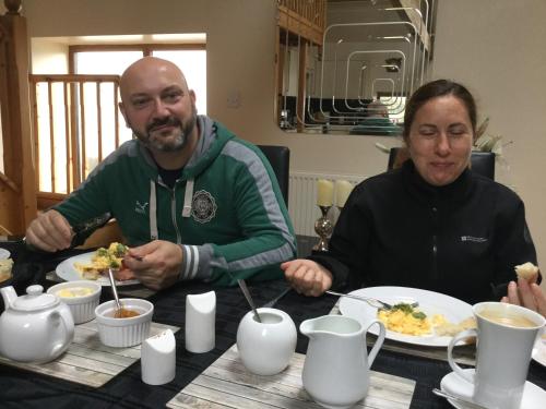 Beudy Bach في Cross Hands: رجل وامرأة يجلسان على طاولة ويتناولان الطعام