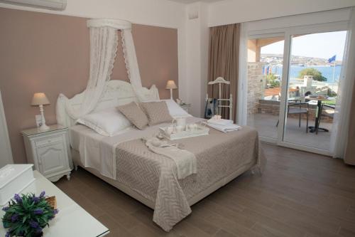 a bedroom with a white bed with a canopy at Blue Horizon Villa & Suites in Sitia