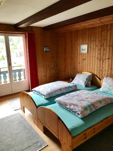 two twin beds in a room with a window at "Falkenstein" in Davos