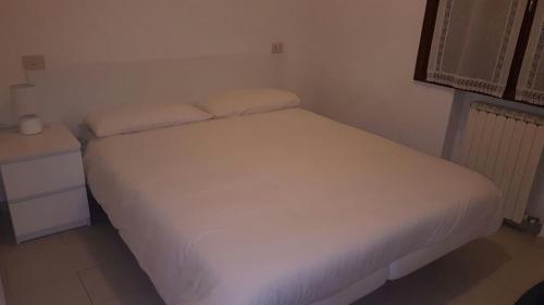 um quarto com uma cama branca e uma mesa de cabeceira em Le Bolle em Maranello