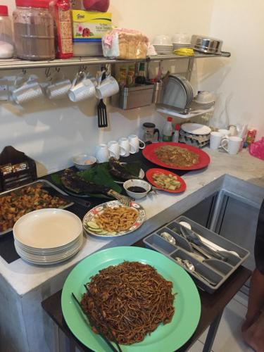 a kitchen with plates of food on a counter at Kuree Hut in Semporna