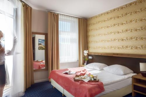 a hotel room with a bed and a mirror at Villa Zagórze in Rumia