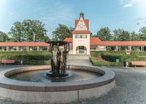 a fountain in front of a building with a building at Hotel & Restaurant Raueneck in Bad Saarow