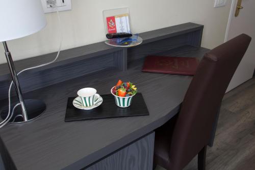 a desk with a bowl of fruit and a plate of food at Hotel Ristorante Eurossola in Domodossola