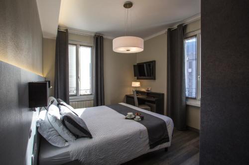 a hotel room with a bed and two windows at Hotel Ristorante Eurossola in Domodossola