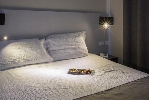 a white bed with a tray of toys on it at Hotel Ristorante Eurossola in Domodossola