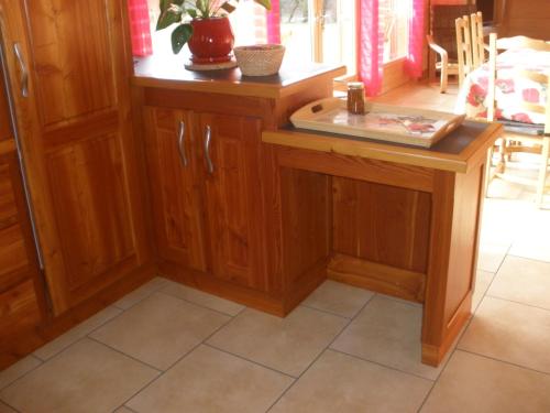 a kitchen with wooden cabinets and a table at Gîte des Conquettes in Salles-la-Source
