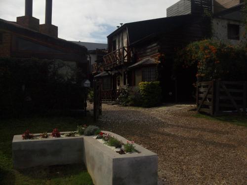 un jardín con flores en un sembrador de hormigón frente a una casa en Cabañas Brisas del Golf en Colón