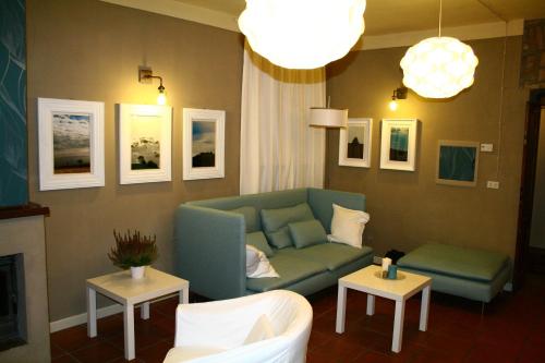a living room with a green couch and two tables at Albergo & Ristorante Selvatico in Rivanazzano