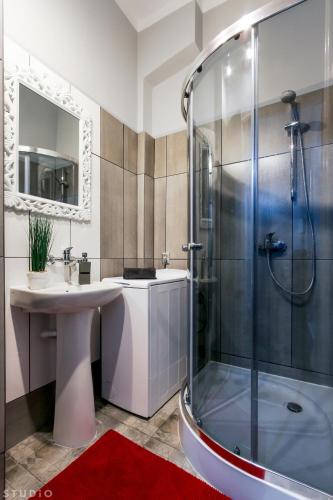 a bathroom with a sink and a shower at ClickTheFlat Wspólna Central Apart Rooms in Warsaw