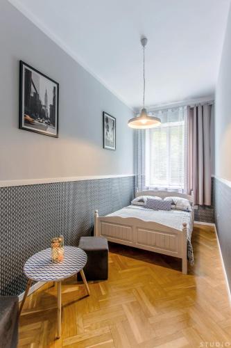 a bedroom with a bed and a table at ClickTheFlat Wspólna Central Apart Rooms in Warsaw