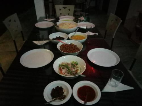 a table with plates and bowls of food on it at The Boundary Yala in Kataragama