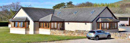 a small house with a car parked in front of it at Peggyslea Farm B&B in Edinburgh
