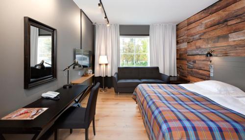 Cette chambre comprend un lit, un bureau et une chaise. dans l'établissement Holiday Club Saariselkä, à Saariselka