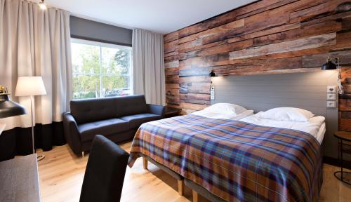 une chambre avec un lit, une chaise et un canapé dans l'établissement Holiday Club Saariselkä, à Saariselka