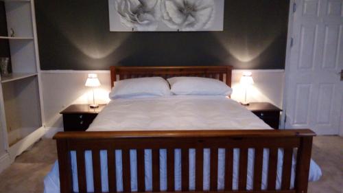 1 dormitorio con 1 cama grande y 2 mesitas de noche en Stonehouse Apartment en Mexborough