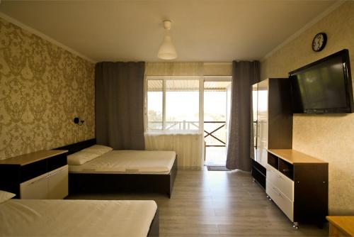 エイスクにあるАпартаменты на Победы 38のベッド2台、薄型テレビが備わるホテルルームです。
