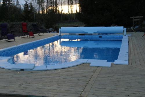 a swimming pool in a yard with chairs around it at Norrängens Alpacka - Det lilla boutiquehotellet med en fluffy twist ! in Sala