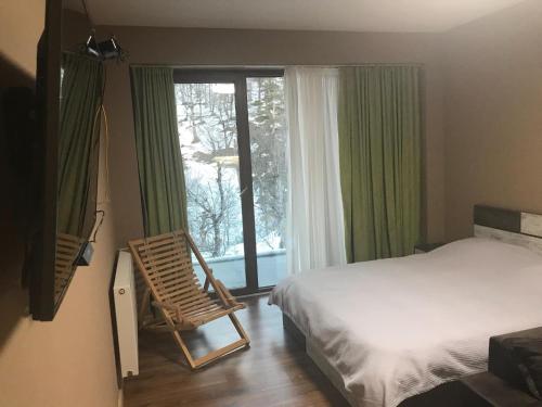 a bedroom with a bed and a chair next to a window at The valley 309 in Nariani