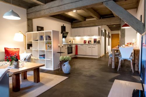 uma cozinha e sala de estar com armários brancos e mesas em Ferienappartements im Speicherwerk em Quedlinburg