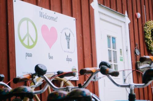 a sign on the side of a building next to a white door at Norrängens Alpacka - Det lilla boutiquehotellet med en fluffy twist ! in Sala